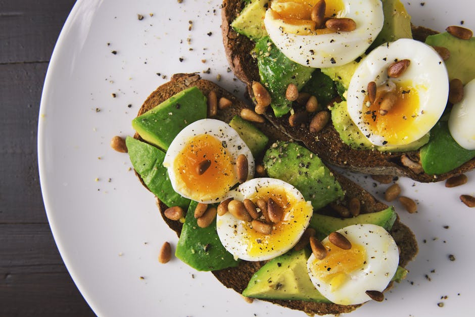 Delicious avocado toast topped with soft-boiled eggs and pine nuts