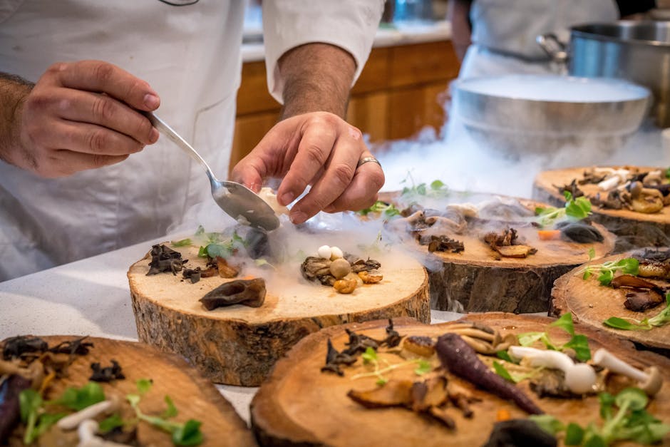 A chef artfully plating a gourmet dish with mushrooms and greens on wood slices