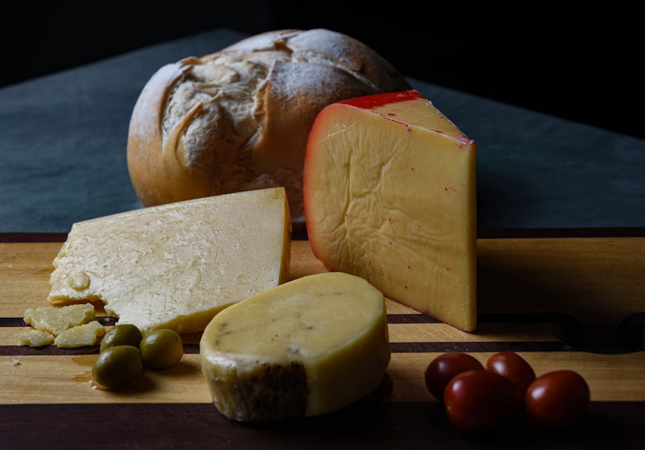 A selection of cheeses and rustic bread on a wooden board